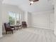 This bedroom features plantation shutters, neutral carpet, trim, and an elevated ceiling at 631 Independence Path, The Villages, FL 32163