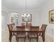 Elegant dining room with a wooden table set beneath a chandelier and decorative mirror, perfect for gatherings at 631 Independence Path, The Villages, FL 32163