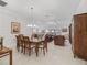 Open dining room features a wooden table, chandelier, and flows into the living room and kitchen area at 631 Independence Path, The Villages, FL 32163