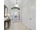 Bright foyer features tile flooring, elegant light fixture and a glass accent front door at 631 Independence Path, The Villages, FL 32163
