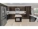 Modern kitchen features stainless steel appliances, granite countertops and dark cabinetry at 631 Independence Path, The Villages, FL 32163