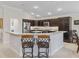 Stylish kitchen with dark wood cabinets, granite countertops, and bar stool seating, ideal for entertaining at 631 Independence Path, The Villages, FL 32163