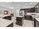 Bright kitchen features stainless steel appliances, granite countertops and dark cabinetry at 631 Independence Path, The Villages, FL 32163