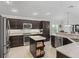 Modern kitchen features stainless steel appliances, granite countertops and dark cabinetry at 631 Independence Path, The Villages, FL 32163