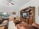 Comfortable living room with plush leather seating, built-in shelving, and a ceiling fan for relaxed living at 631 Independence Path, The Villages, FL 32163