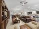 Inviting living space boasts comfortable seating, a ceiling fan, and an open flow to the dining and kitchen areas at 631 Independence Path, The Villages, FL 32163