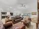 Spacious living area features leather seating and neutral tones, seamlessly connecting to the kitchen and dining spaces at 631 Independence Path, The Villages, FL 32163