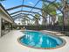 Screened-in pool with a waterfall feature and a patio with outdoor seating and a barbeque at 631 Independence Path, The Villages, FL 32163