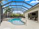 This property features a pool with waterfall feature, screened-in enclosure, and covered patio area at 631 Independence Path, The Villages, FL 32163