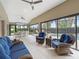 Enclosed sunroom features an outdoor seating area overlooking the pool and yard at 631 Independence Path, The Villages, FL 32163