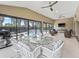 Enclosed sunroom with a glass top dining table and chairs overlooking the pool at 631 Independence Path, The Villages, FL 32163