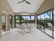 Enclosed sunroom with a glass top dining table and chairs overlooking the yard at 631 Independence Path, The Villages, FL 32163