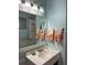 Bright bathroom vanity with a large mirror, decorative towels and ample lighting at 66 Elmwood Trl, Deland, FL 32724