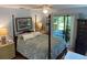 Comfortable bedroom with a four-poster bed, dresser, and access to a screened-in porch at 66 Elmwood Trl, Deland, FL 32724