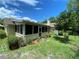 Home's screened-in porch is visible in the well-maintained backyard with lush greenery at 66 Elmwood Trl, Deland, FL 32724