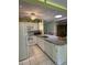 Bright kitchen with a skylight, white cabinetry, granite countertops, and modern appliances at 66 Elmwood Trl, Deland, FL 32724