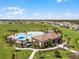 Great community pool, splash pad, and playground, surrounded by green space and the homes of the community at 7627 Taormina Way, Clermont, FL 34714