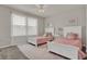 Bedroom featuring twin beds, ceiling fan, and a patterned area rug at 7627 Taormina Way, Clermont, FL 34714