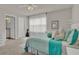 Bright bedroom with an ensuite bathroom, decorated with stylish turquoise accents, plush pillows, and plenty of natural light at 7627 Taormina Way, Clermont, FL 34714