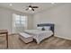 Bright bedroom features plush carpet, ceiling fan, window with blinds, and stylish blue headboard on queen bed at 7627 Taormina Way, Clermont, FL 34714