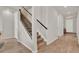 Hallway with hardwood-style flooring, carpeted stairs and dark wood railing, with white doors and light fixtures at 7627 Taormina Way, Clermont, FL 34714