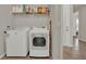 Functional laundry room with modern appliances and shelving for organized storage solutions at 7627 Taormina Way, Clermont, FL 34714