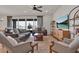 Well-lit living room with ceiling fan, modern furnishings, and sliding door to screened-in porch at 7627 Taormina Way, Clermont, FL 34714