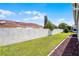 A tranquil backyard offering privacy with a solid wall, along with well kept lawn and landscaping at 815 Cortez Ave, Lady Lake, FL 32159
