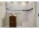Well-lit bathroom with tile shower and decorative accent tiles and corner cabinet at 815 Cortez Ave, Lady Lake, FL 32159