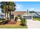 Charming single-story home with paver driveway, palm trees, and well-maintained landscaping at 815 Cortez Ave, Lady Lake, FL 32159