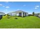 Manicured backyard featuring a screened lanai and lush green lawn at 8178 Penrose Pl, Wildwood, FL 34785