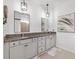 Bathroom with double vanity, granite countertop, and modern mirrors at 8178 Penrose Pl, Wildwood, FL 34785