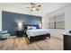 A main bedroom is accented by a deep blue accent wall and features hardwood floors at 8178 Penrose Pl, Wildwood, FL 34785