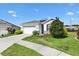 Pleasant single-Gathering home featuring a two-car garage, lush lawn, and stone accents at 8178 Penrose Pl, Wildwood, FL 34785