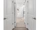 Hallway with multiple doors leading to different rooms and a view of a sliding barn door at 8178 Penrose Pl, Wildwood, FL 34785