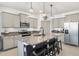 Modern kitchen boasts granite countertops, stainless appliances, and a central island with barstool seating at 8178 Penrose Pl, Wildwood, FL 34785