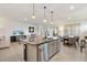 Open concept kitchen features island seating, stainless appliances and connects to a comfortable living area at 8178 Penrose Pl, Wildwood, FL 34785