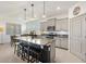 Modern kitchen with stainless steel appliances, granite countertops, island seating, and light gray cabinets at 8178 Penrose Pl, Wildwood, FL 34785