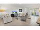 Comfortable living room with neutral decor, tile flooring, and sliding glass doors to the patio at 8178 Penrose Pl, Wildwood, FL 34785