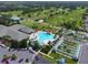Aerial view of a golf course, pool, bocce ball court, and clubhouse with ample parking at 8779 Se 141St Lane Rd, Summerfield, FL 34491
