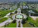 Wide aerial shot of a community with a beautiful fountain entrance surrounded by lush landscaping at 8779 Se 141St Lane Rd, Summerfield, FL 34491