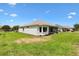 View of a well maintained backyard with green grass and partial view of the patio at 8779 Se 141St Lane Rd, Summerfield, FL 34491