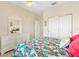 Cozy bedroom with a floral bedspread, white dresser with mirror, and a closet at 8779 Se 141St Lane Rd, Summerfield, FL 34491