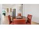 The dining area features a round wooden table, red leather chairs, and a modern chandelier at 8779 Se 141St Lane Rd, Summerfield, FL 34491