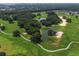 Scenic aerial view of a lush golf course with ponds and mature trees, offering recreational space at 8779 Se 141St Lane Rd, Summerfield, FL 34491