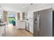 Modern kitchen with white cabinets, stainless steel appliances, and a view of the dining area at 8779 Se 141St Lane Rd, Summerfield, FL 34491