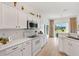 Charming kitchen with white cabinets, an oven, and a window overlooking the outdoor golf course at 8779 Se 141St Lane Rd, Summerfield, FL 34491
