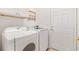 Neat laundry room with white washer and dryer, cabinets and white door at 8779 Se 141St Lane Rd, Summerfield, FL 34491