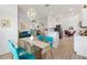 Open concept living space flows into the dining area with turquoise chairs and modern light fixture at 8779 Se 141St Lane Rd, Summerfield, FL 34491