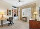 Well-lit home office with built-in shelving, plantation shutters, and light wood floors at 8779 Se 141St Lane Rd, Summerfield, FL 34491